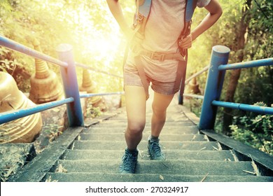  woman hiker climbing stairs at mountain peak 