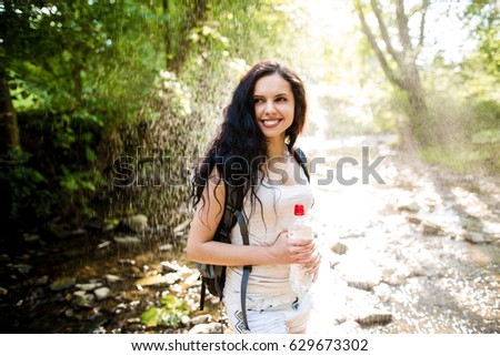 Woman hiker enjoying amazing landscapes near wild mountain river.