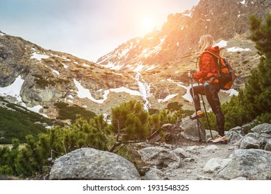Woman hiker, hiking backpacker traveler camper walking on the top of mountain in sunny day under sun light. Beautiful mountain landscape view.