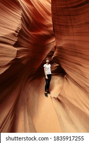 Woman Hiker In A Narrow Cave Of Antelope Canyon. Vertical Shot