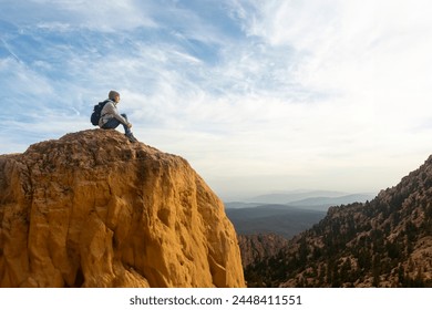 Woman hiker sitting on top of a rocky mountain looking at the view - Powered by Shutterstock