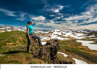 Woman hiker standing on the rock. Panoramic view on volcanic valley, Kamchatka, Russia