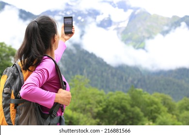 Woman Hiker Taking Photo With Cell Phone At Mountain Peak In Tibet,china 