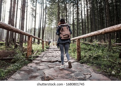 Woman Hiker Walking By Stone Trail In Forest