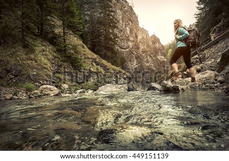 Woman hiking around mountains near the river at spreeng time.