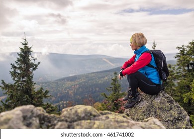 Woman Hiking In Autumn Mountains And Woods. Celebrate Mountain Top, Inspiring Recreation And Healthy Lifestyle Outdoors In Beautiful Nature. Motivated Backpacker Blond Female Looking At Sunset View.