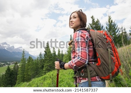 Woman hiking with backpack near mountains
