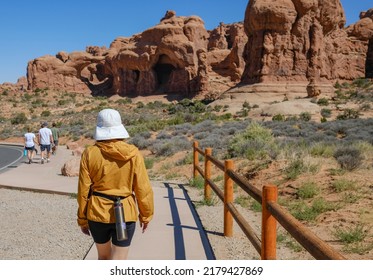 A Woman Is Hiking To The Canyon During Summer And Sunshine. Utah USA Arches National Park. 