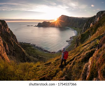 A woman hiking during midnight sun. Active vacation in Norway. Located on Andøya island in Vesterålen north of Norway. Sunset and backpack girl. - Shutterstock ID 1754537366