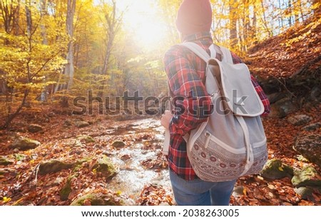 Woman hiking looking at scenic view of autumn foliage mountain landscape. Outdoor adventure travel lady standing relaxing and hiking in nature in autumn season.