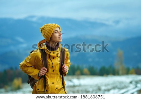 Woman hiking in mountains alone, calm treveler girll peaceful looking away, enjoing winter nature outdoors