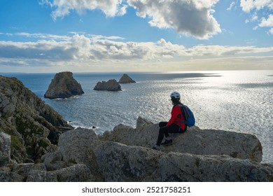 woman hiking on the Coastal hiking trail GR 34 in Brittany and enyoing the awesome view from Cape Pen Hir in Camaret sur Mer, France - Powered by Shutterstock