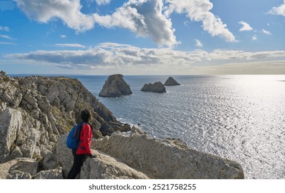 woman hiking on the Coastal hiking trail GR 34 in Brittany and enyoing the awesome view from Cape Pen Hir in Camaret sur Mer, France - Powered by Shutterstock