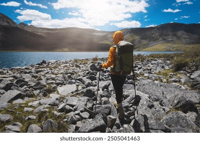 woman hiking on high altitude mountains, walking to a beautiful lake