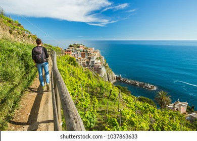 Woman hiking on the path in vineyard near Manarola village. Cinque Terre. Liguria, Italy.