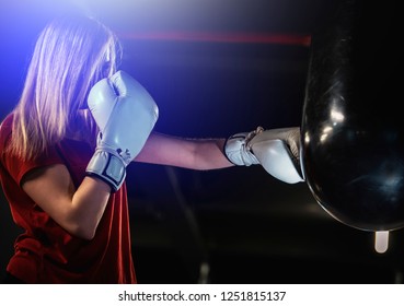 Woman Hits The Boxing Heavy Bag In The Gym. Hard Mixed Martial Arts Training