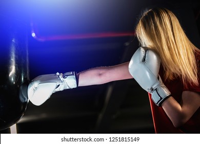 Woman Hits The Boxing Heavy Bag In The Gym. Hard Mixed Martial Arts Training