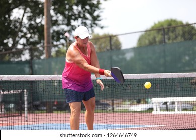 A Woman Hits A Shot Playing Pickleball