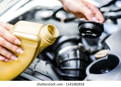 Woman Hold Basket And Tap And Going To Change Motor Oil On Car Engine. Pour Yellow Liquid Into Vehicle.