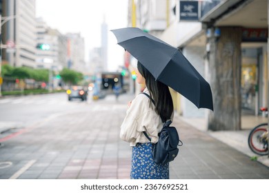 Woman hold with black umbrella at Taipei city - Powered by Shutterstock