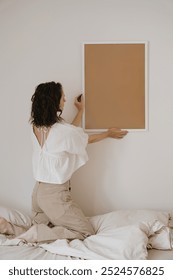 Woman hold blank photo frame with empty copy space over white background. Aesthetic minimalist artist work concept. Soft beige neutral tone