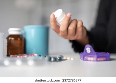 Woman hold bottle of drug tablet painkiller or vitamin supplement reading label ready to organizing medicine at home. medication healthcare concept - Powered by Shutterstock