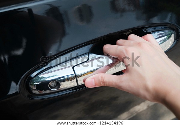 Woman hold car\'s\
door by her hand to unlock and pull automobile\'s door for valet\
service at department store\
