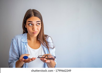 woman hold contact lenses and glasses in hands close up. concept of choice of vision protection. Girl holding glasses in one hand and contact lens other hand. Girl Comparing Contacts to Eyeglasses 