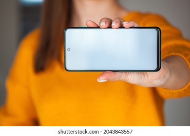 Woman Hold Mobile Phone Screen Mocap In Hands In The Orange Sweater