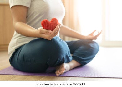 Woman Hold Red Yarn Heart Shape In Hand Doing Yoga Post At Home. Yoga Is Good For Heart - Meditation Concept.