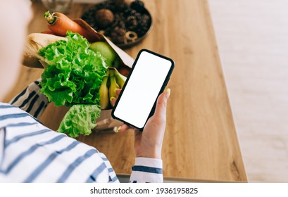 Woman hold the smartphone with white screen, mock up. Online food market concept. - Powered by Shutterstock