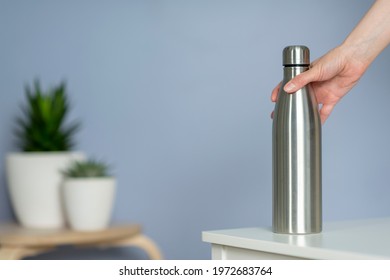 Woman Hold Steel Water Bottle On The Table At Home. Zero Waste.