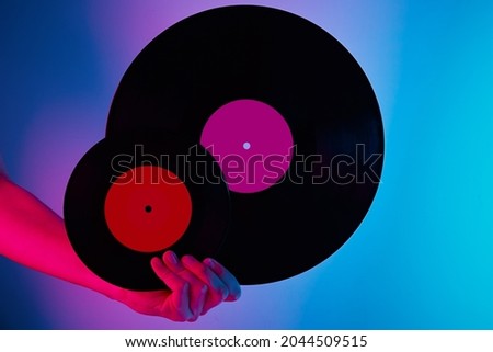 Woman hold two retro vinyl disc in hands, toned photo. Vintage style 80s and 90s years