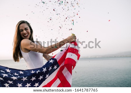 Woman holding American flag with confetti celebrating