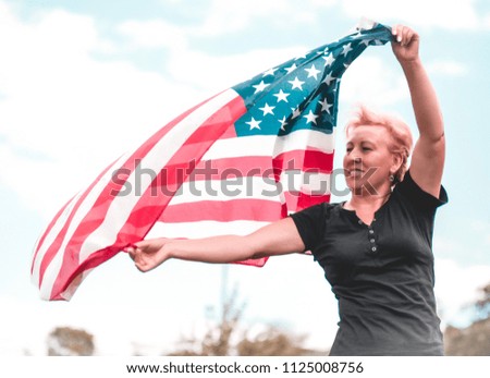 Woman holding american flag in the wind