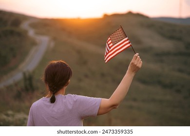 Woman holding american USA flag in the sunset. Independence Day or traveling in America concept. - Powered by Shutterstock