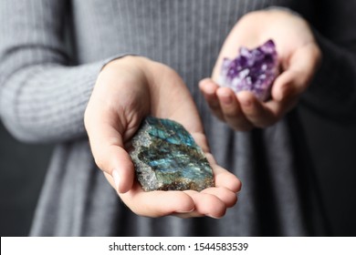 Woman holding amethyst and labradorite gemstones, closeup