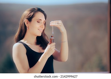 
Woman Holding Anti-Aging Serum For Her Skin Routine. Happy Lady Using Essential Oils For Aromatherapy
