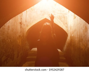 Woman holding arms hands in praying position in a sacred place.