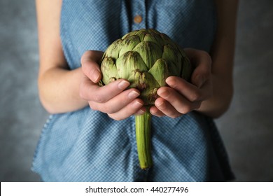 Woman holding artichoke
