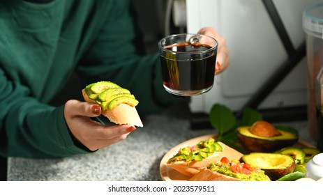 Woman Holding Avocado Toast And Coffee Cup.