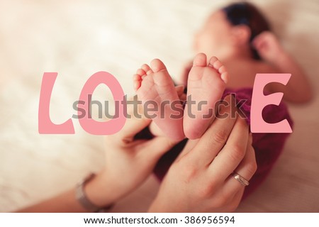 Woman holding baby feet closeup. Love concept. Childhood. Motherhood.