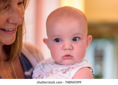 Woman Holding Baby Girl Wearing Bib And Drool