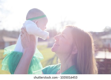 Woman Holding Baby Up Outside In Bright Sunlight - Overexposed For Effect