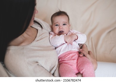 Woman Holding Baby Wear Pajamas Lying On Mother Hand Crying. Sad Child Girl Have Colics And Stomach Ache At Home. Motherhood. 