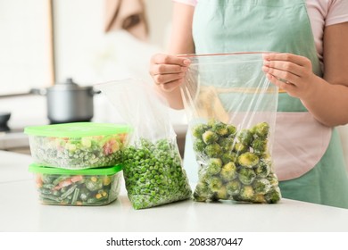 Woman Holding Bag With Frozen Vegetables In Kitchen