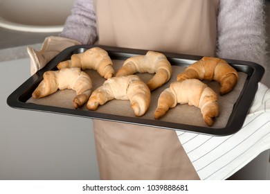 Woman Holding Baking Sheet With Freshly Baked Croissants, Closeup