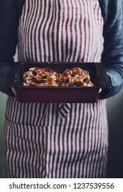 Woman Holding Baking Sheet With Homemade Cinnamon In Her Hands 