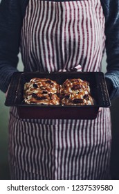 Woman Holding Baking Sheet With Homemade Cinnamon In Her Hands 