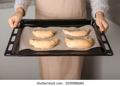 Woman Holding Baking Sheet With Uncooked Croissants, Closeup